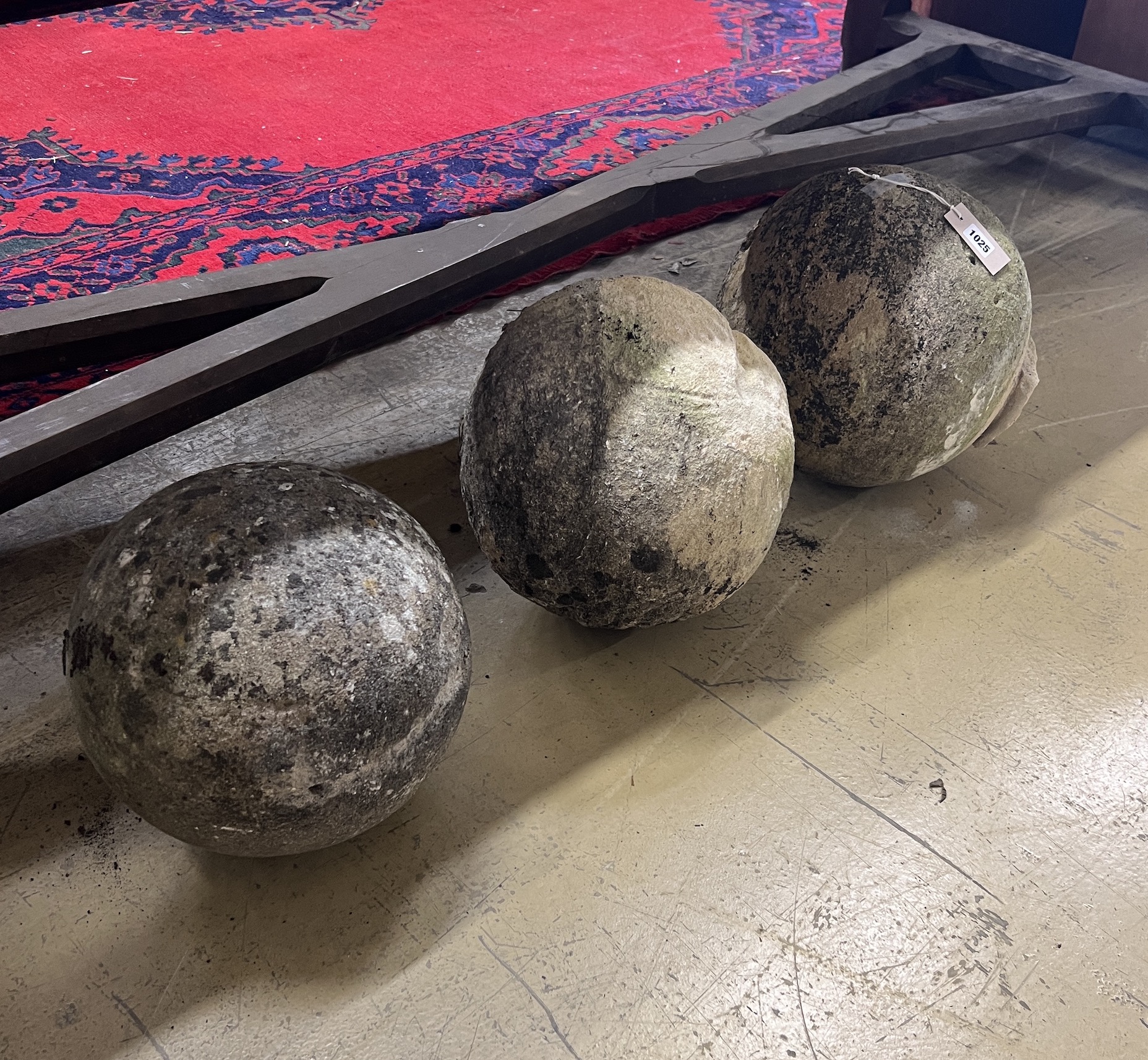 A trio of graduated reconstituted weathered stone ball finials, largest height 37cm
